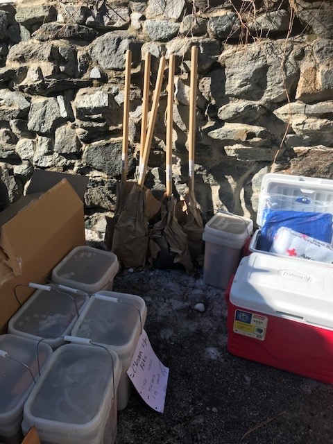 Push brooms, buckets and emergency supplies are seen in the photo leaning against a wall.