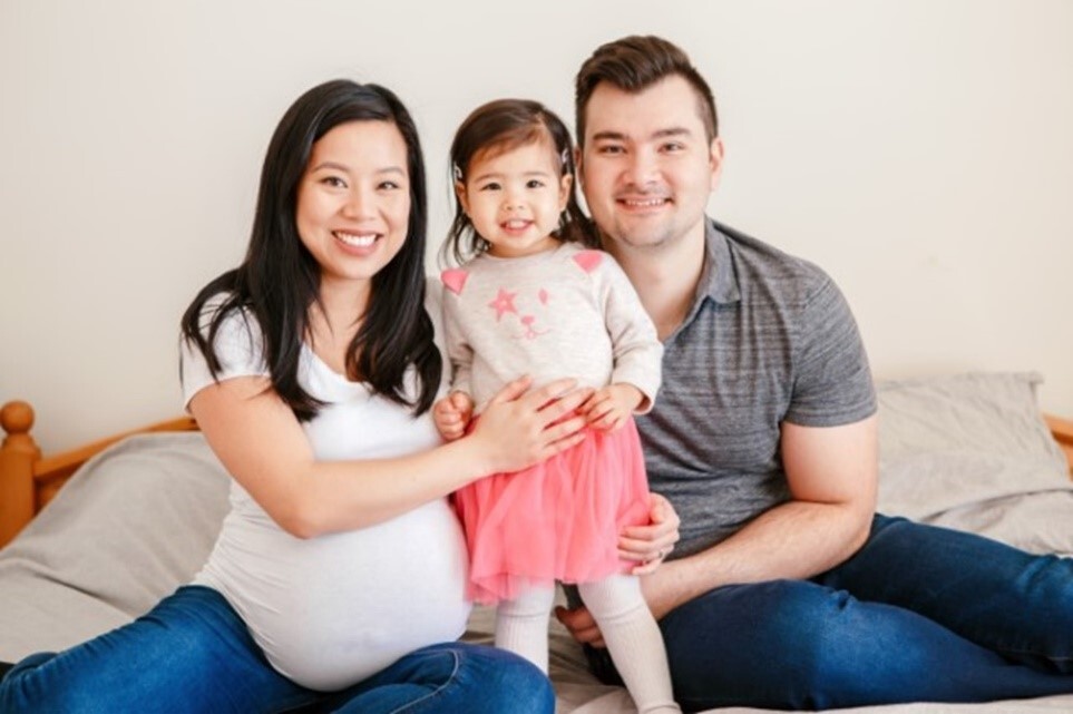 A photo of a woman, little girl and man smiling.