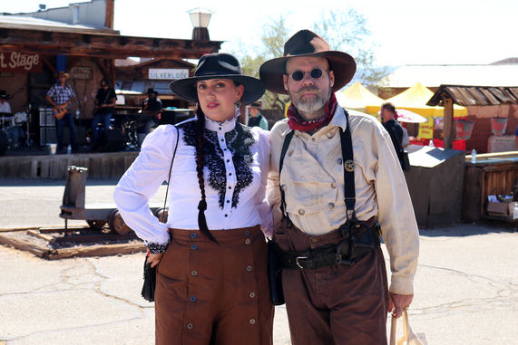 A man and woman dressed in 1880s attire pose for the camera at Calico Ghost Town in 2022.