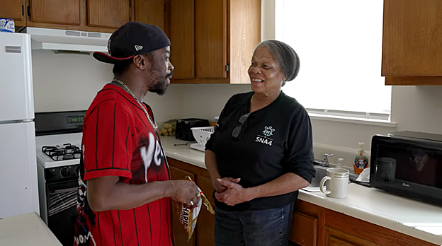 Two people talking in a kitchen