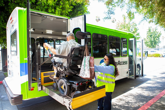 A person in a wheelchair being lifted onto a bus