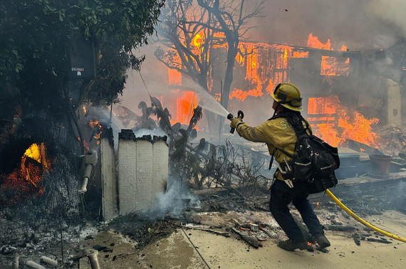A San Bernardino County firefighter battles flames during recent wildfires in Los Angeles County