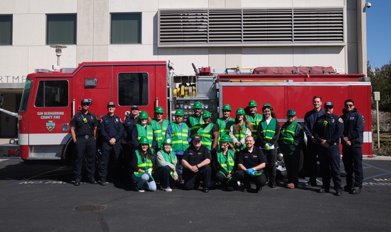 Group of emergency responders posing in front of a fire truck.