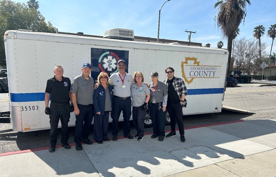 A group of ICEMA staff and Medical Reserve Corps volunteers stand together at the ICEMA mobile field hospital.