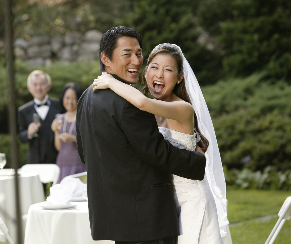 A newly married couple embraces and smiles at the altar