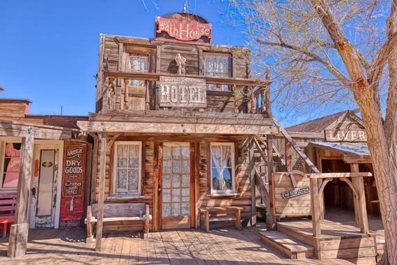 Image of a wooden building with signs reading "Bath House" and "Hotel."