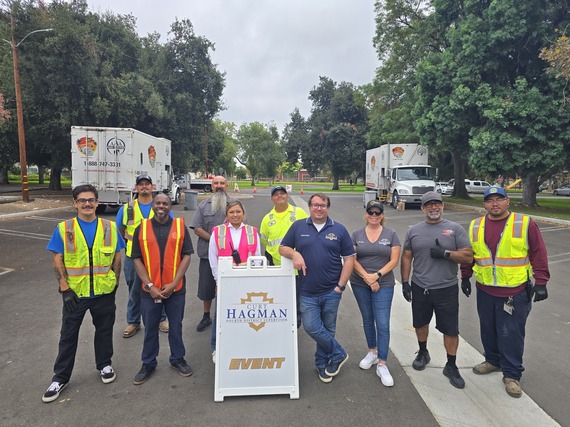 A group of volunteers and staff posing at a Curt Hagman community event with shred trucks.