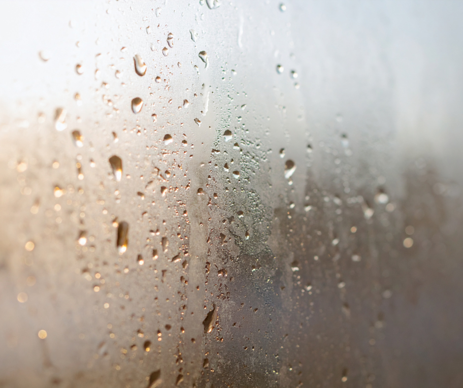 A blurry window is covered by raindrops. The word "blustery" would apply to this picture.