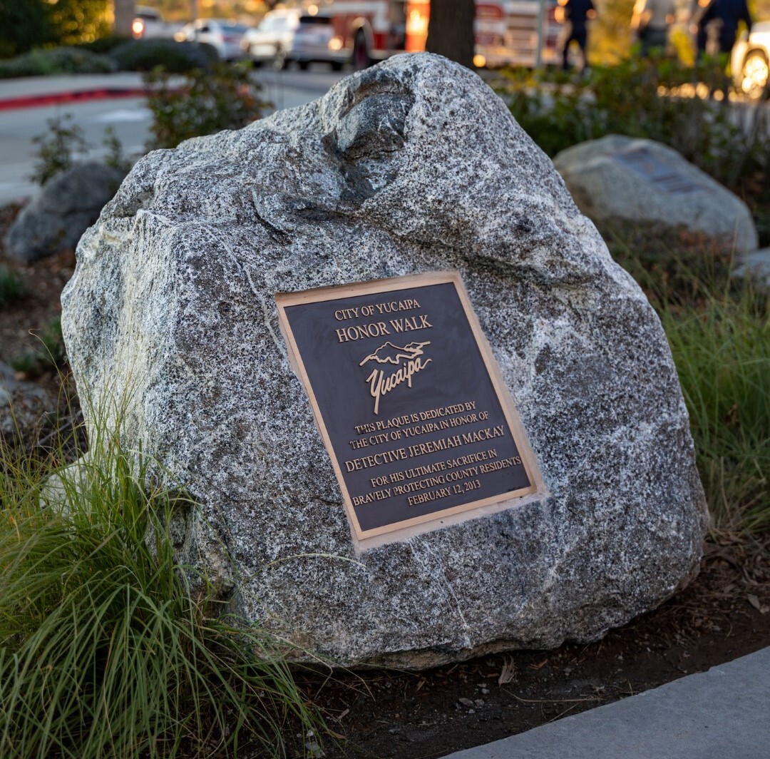 A large rock at Yucaipa's Honor Walk displays a plaque recognizing the service and ultimate sacrifice of Sheriff's Detective Jeremiah MacKay