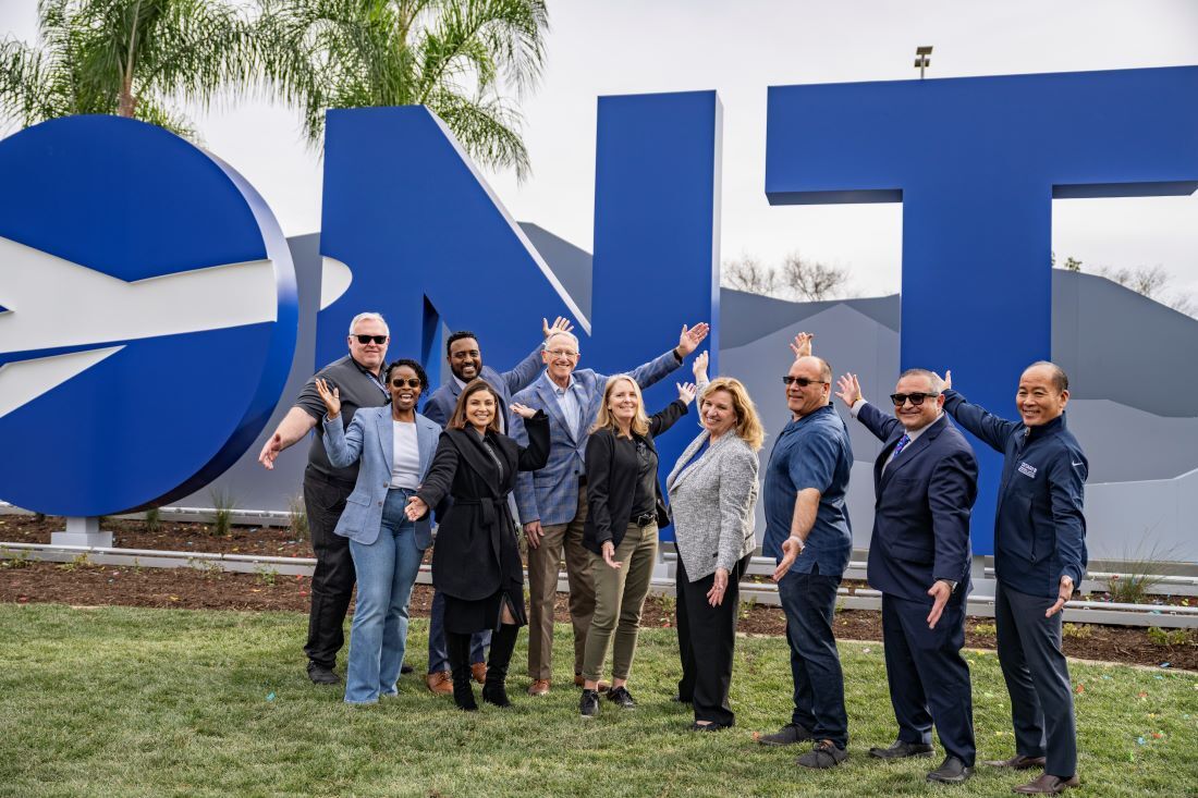 Ontario International Airport board members and staff posing in front of the new ONT monument sign.