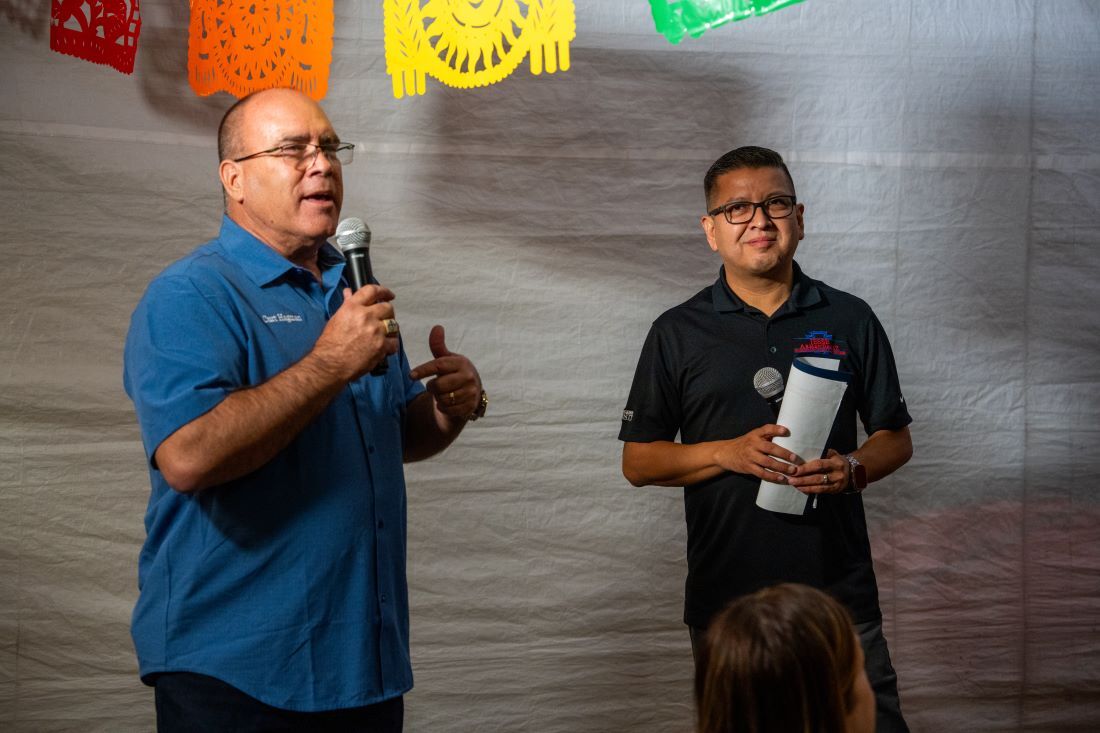 Supervisor Curt Hagman speaks into a microphone, with Supervisor Jesse Armendarez in the background at the Let’s Taco ’Bout It event.