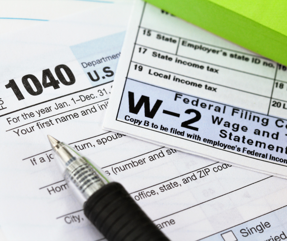 USA tax form 1040 and a W-2 form sit alongside a fountain pen, waiting to be filled out.