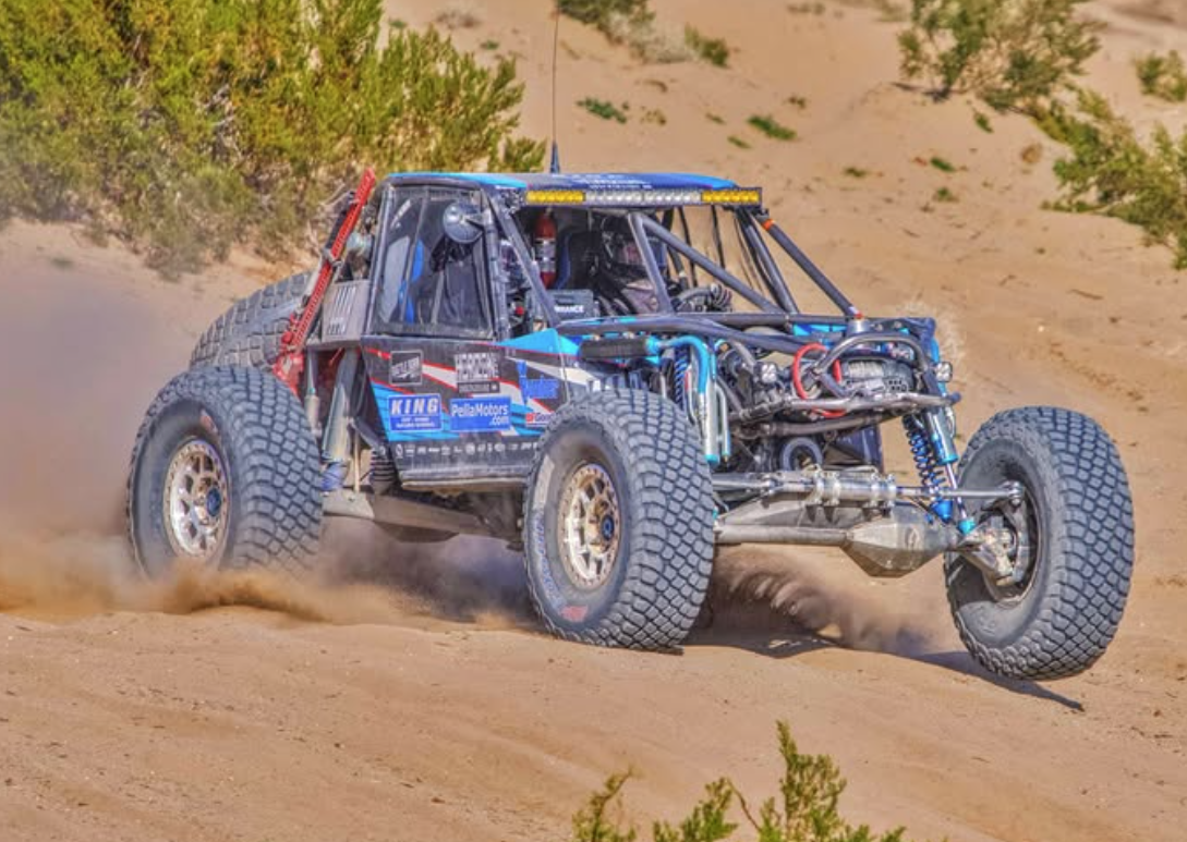 Randy Slawson's blue-toned "Bomber" off road vehicle plows through the desert with a cloud of dust.