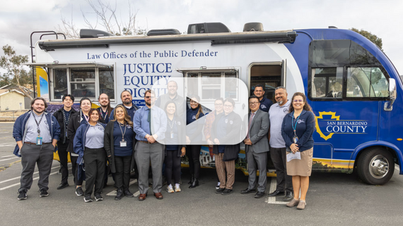 group of people standing in front of the mobile defense vehicle with a play button overlayed