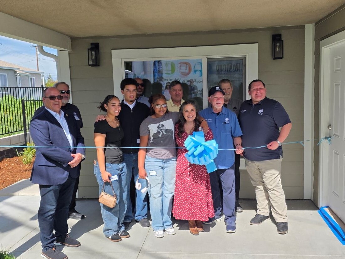 Group gathers for ribbon cutting at new Habitat for Humanity home.