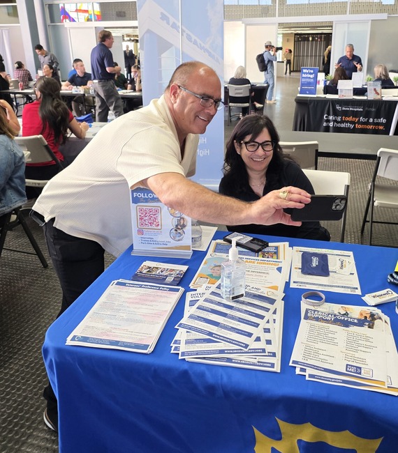 Supervisor Curt Hagman takes a selfie with a recruiter at a San Bernardino County job fair booth promoting county career opportunities.