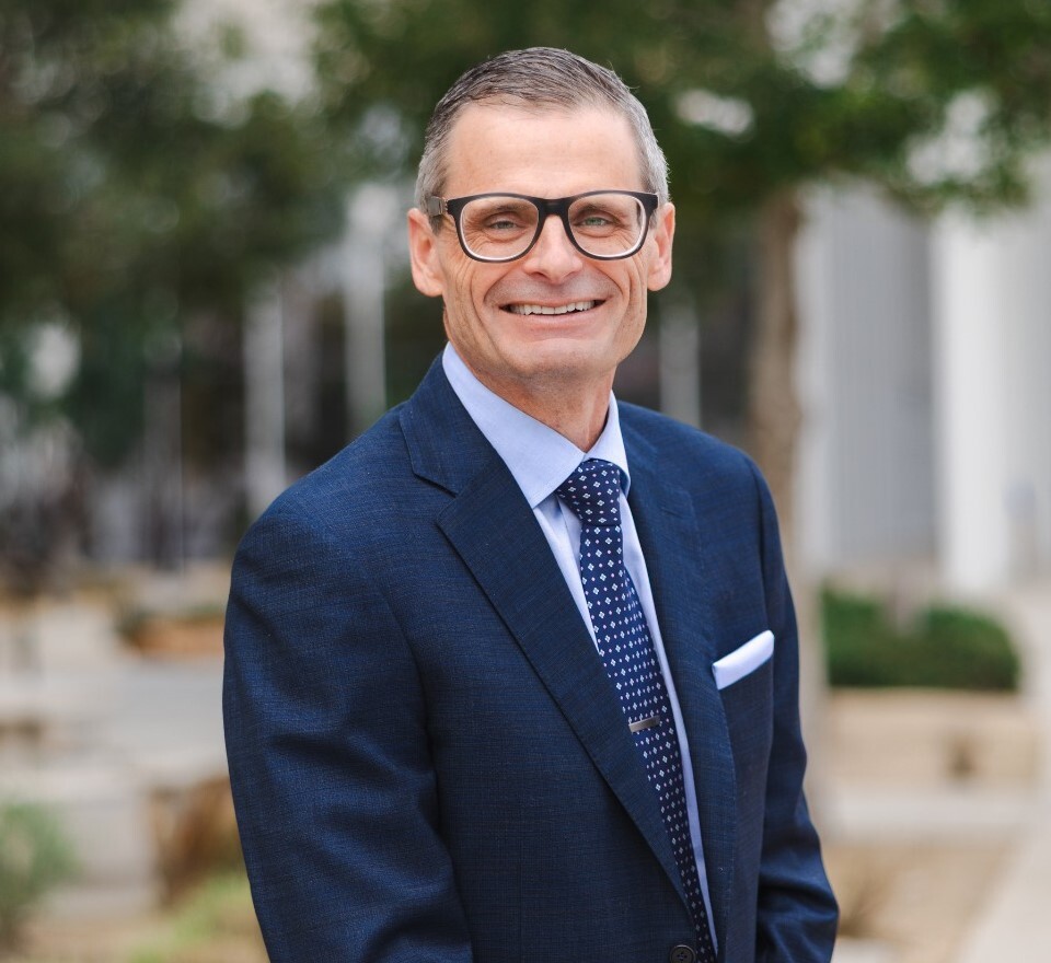 Loma Linda Health President and CEO Dr. Anthony Hilliard stands smiling on the Loma Linda University campus.