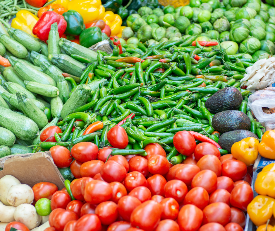 A colorful display of fresh produce at a farmers market, arranged in rows on a table.