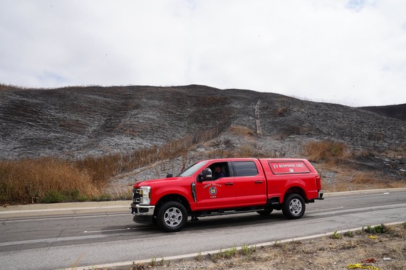 Chino Valley Fire District EV Response Unit in front of a burned hillside following a fire incident.