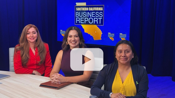 Three women sit at a table in a TV studio with a Southern California Business Report sign on a screen behind them.