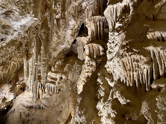 A view of natural tone stalactites and stalagmites inside a limestone cave.