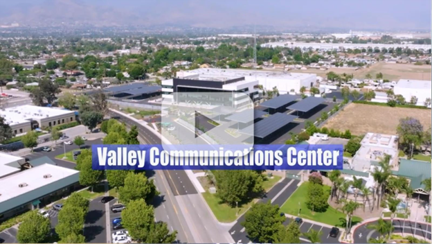 Aerial view of the campus with parking canopies and surrounding neighborhood. Text: “Valley Communications Center” with video play button.
