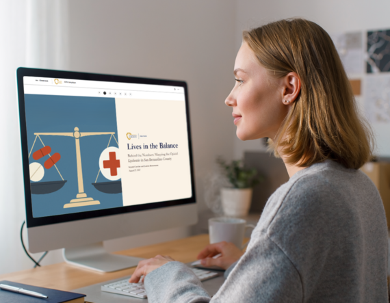 Woman working at a computer displaying the Lives in the Balance opioid data StoryMap.
