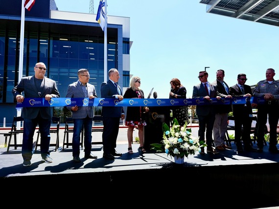Community leaders and public safety officials gather on stage for a ribbon-cutting ceremony outside the new Valley Communications Center.