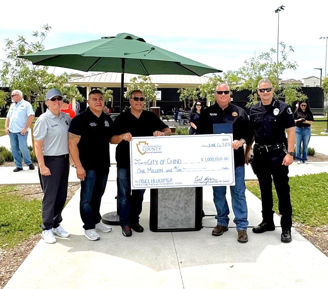 Community leaders and police officials hold a ceremonial $1 million check supporting a police helicopter program in Chino.
