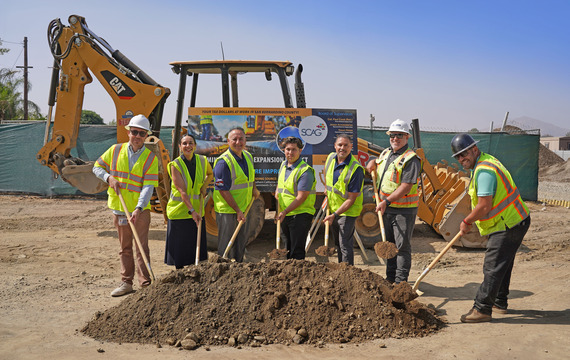 County officials and project partners hold shovels during a ceremonial groundbreaking at a construction site while wearing safety vests and hard hats.
