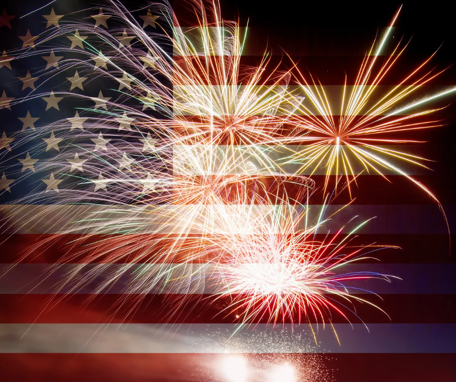 the blurred image of an American flag in the background while fireworks burst in the foreground