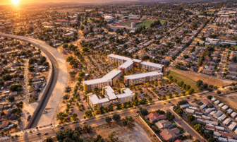 An aerial view of a sprawling suburban landscape at sunset, featuring a large, U-shaped complex surrounded by a parking area. 
