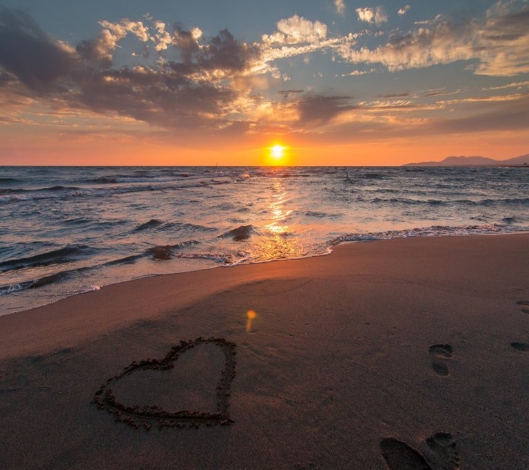 Heart in the sand at sunset