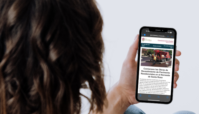 Woman Looking at City Connections Newsletter on Cell Phone_SPA_700x400