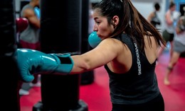 iLoveKickboxing stock photo of person punching bag wearing a branded tank top