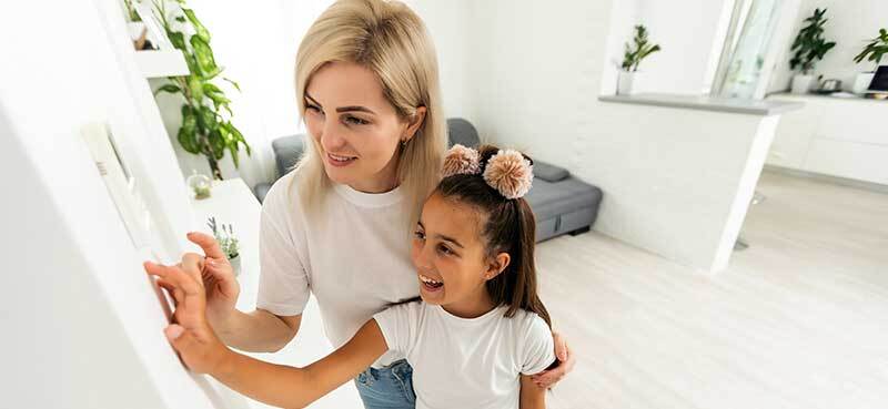 Family adjusting a thermostat