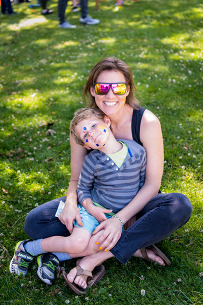 mom and son smiling on grass
