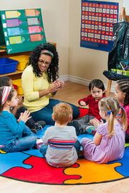 teacher leading a group of preschool children at storytime