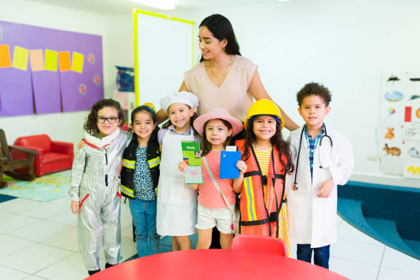 row of children standing in front of a woman in a classroom