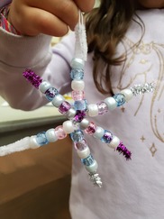 child holding a snowflake craft
