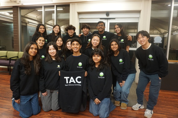 Teen Advisory Committee members wearing matching Sunnyvale shirts pose together indoors, holding a TAC sweatshirt for a group photo.