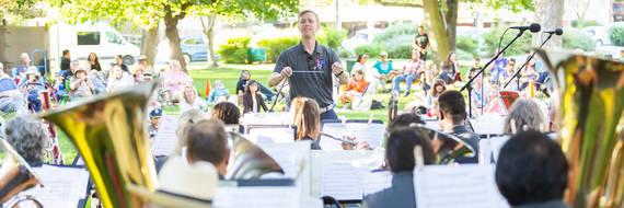 Walnut Creek Concert Band performing in Civic Park with picnickers in the background