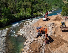 Machinery removing sediment along the riverbank below Colgate powerhouse