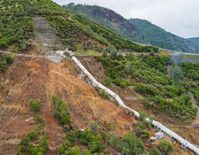 A steep, eroded hillside and displaced pieces of pipe above Colgate powerhouse