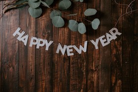 A happy new year sign rests on a wooden table