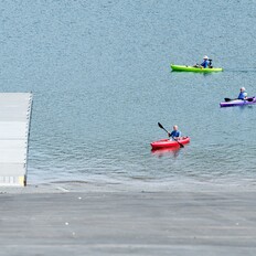 Kayakers paddle toward the Spillway boarding dock at Lake Oroville. 