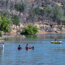 Visitors swim and float on a raft at the Loafer Creek swim beach at Lake Oroville. 