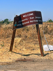 A "Welcome to the Delta National Heritage Area" sign damaged by a vehicle crash