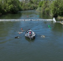 Drift boat users paddle between a designated boat passage area to navigate over a fish monitoring station installed in the Stanislaus River.