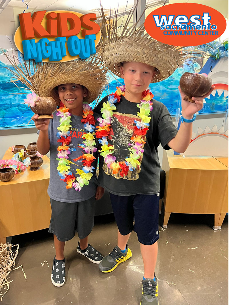 Two boys wearing leis at Kids Night Out